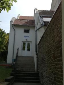 een trap naar een wit gebouw met een deur bij Tihany Község Önkormányzat - Ifjúsági Szállás in Tihany