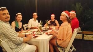 a group of people sitting around a table wearing christmas hats at Ao Luek Panoramic Pool-SHA Plus in Ao Luk