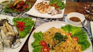 a wooden table with plates of food on it at Ao Luek Panoramic Pool-SHA Plus in Ao Luk