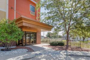 um edifício vermelho com uma árvore ao lado de um passeio em Econo Lodge Inn & Suites Fairgrounds em Des Moines