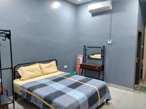 a bedroom with a bed and a blue wall at Shah Dangau Loqstaq Muslim Homestay in Kampong Sungai Mati