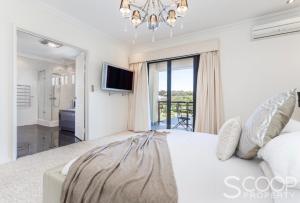 a bedroom with a large bed and a television at LUXURY VILLA W POOL & SPAS in Coogee