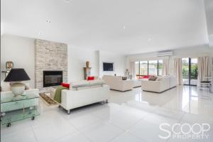 a living room with white furniture and a fireplace at LUXURY VILLA W POOL & SPAS in Coogee
