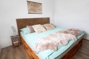 a bed with a blanket and pillows on it at Panorama Apartmanok in Villány