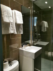 パリにあるホテル ヴィクトリアのバスルーム(トイレ、洗面台、シャワー付)