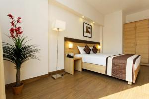 Habitación de hotel con cama y maceta en Silver Oak, en Gurgaon