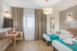 um quarto de hotel com duas camas e uma secretária em Appart'City Classic Annemasse Centre - Pays de Genève em Annemasse