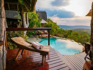 a bench sitting on a deck next to a swimming pool at Nedile Lodge in Welgevonden Game Reserve