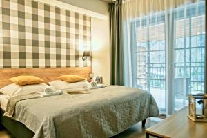 sypialnia z łóżkiem i dużym oknem w obiekcie Apartamenty Magia Gór w mieście Szczawnica