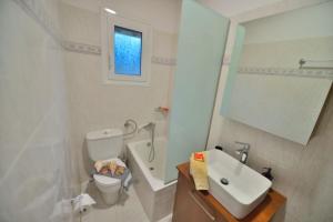 uma casa de banho branca com um lavatório e um WC em Nonda's Mansion em Falasarna