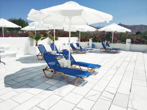 a group of chairs and umbrellas on a patio at Ikaros Studios & Apartments in Naxos Chora