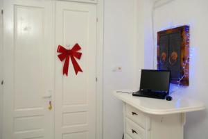 Habitación con puerta blanca y escritorio con ordenador portátil. en Apartmani Seyda en Sarajevo