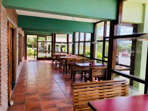 阿肖海Hotel Scoglie的餐厅设有木桌、长凳和窗户。