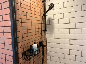 a shower in a tiled bathroom with a shower head at Wontonmeen in Hong Kong