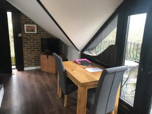 - une salle à manger avec une table et des chaises en bois dans l'établissement Hunters Hide Apt, à Littlehampton