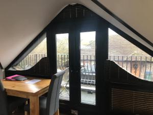 a dining room table with a view of a balcony at Hunters Hide Apt in Littlehampton