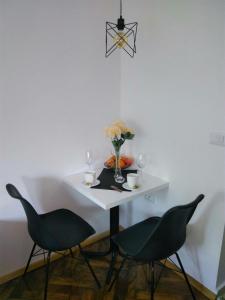 a white table with two chairs and a vase with flowers at Labroski Apartments in Ohrid