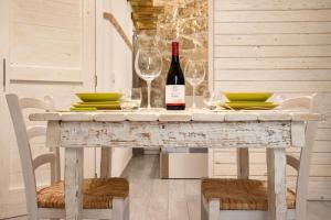 una mesa con una botella de vino y dos copas en Jureca Guest House, en Siracusa