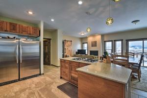 a kitchen with a stainless steel refrigerator and a table at Majestic Granby Home with Hot Tub, Deck and Views! in Granby