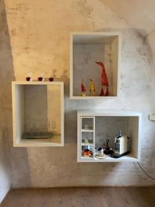une chambre avec deux étagères blanches et un grille-pain sur un mur dans l'établissement Chambreplus Kriski, à Gand