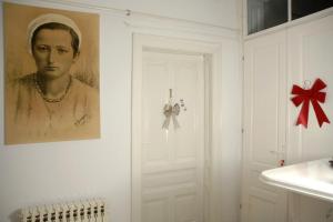 uma porta branca com um retrato de um homem na parede em Apartmani Seyda em Sarajevo