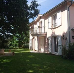 uma casa branca com uma varanda e um quintal em l'Ecrin de Vert em Saint-Alban-du-Rhône