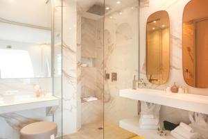 a bathroom with two sinks and a shower at Hôtel Marinca & Spa in Olmeto
