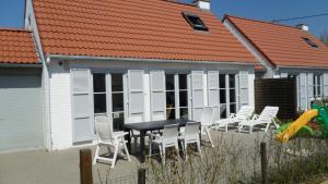 einen Tisch und Stühle vor einem Haus in der Unterkunft Huisjes aan zee in De Haan