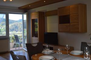 a dining room with a table with chairs and a television at Ferienwohnung im Herzen des Renchtals in Oppenau