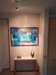 a painting hanging on a wall with a table at IVY'S CORNER in Luxembourg