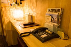 a black phone sitting on a desk in a office at Hotel Hammer-Mainz Hauptbahnhof in Mainz