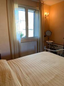 a bedroom with a large bed and a window at Casa Delle Olive in Dolceacqua