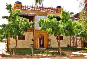 a house with two trees in front of it at Residencial Bem-te-vi in Jericoacoara