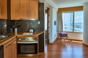 a kitchen with wooden cabinets and a sink and a stove at RQ Santiago in Santiago