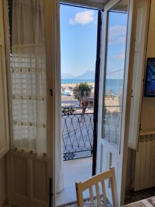 una puerta a un balcón con vistas al océano en Pandora, en Porticello