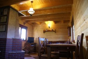 uma sala de jantar com uma mesa e uma televisão em Domy nad jeziorem Blanki em Lidzbark Warmiński