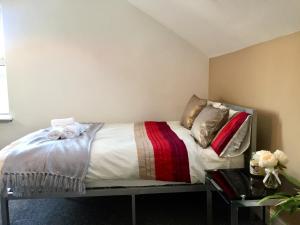uma cama com almofadas num quarto em BELMONT Apartments em Liverpool