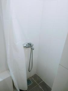 a shower with a hose in a white bathroom at Future in Kyiv