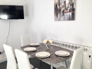 uma sala de jantar com uma mesa e cadeiras brancas em BELMONT Apartments em Liverpool