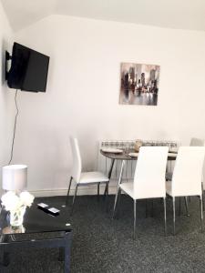 uma sala de jantar com uma mesa e cadeiras brancas em BELMONT Apartments em Liverpool