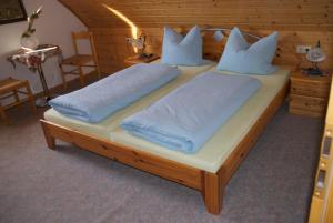 a bedroom with two beds with blue pillows at Gasthof Jägerheim in Birgland