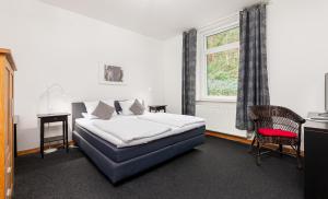 a bedroom with a bed and a window at Hotel Rutherbach in Essen