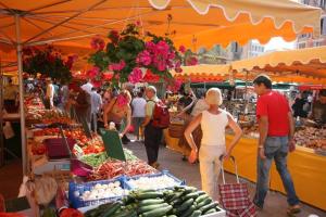 un groupe de personnes parcourant un marché avec des produits dans l'établissement Bel appartement T3 Mourillon à 5 min des Plages - vue mer, à Toulon