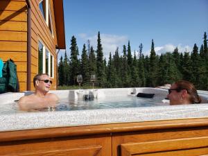two people in a hot tub in a house at Denali Wild Stay - Bear Cabin with Hot Tub and Free Wifi, Private, sleep 6 in Healy +25 photos
