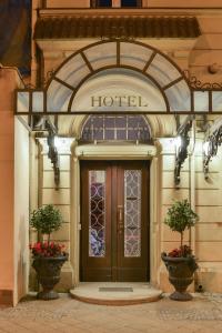 an entrance to a hotel with a door and two plants at Altstadthotel Am Theater in Cottbus