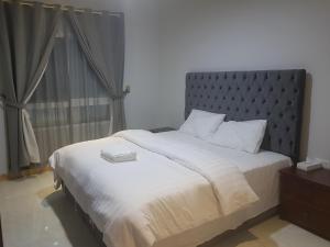 a bedroom with a large bed with a silver headboard at درة الخوير للشقق الفندقيه in Muscat