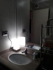 La salle de bains est pourvue d'un lavabo éclairé à côté d'un miroir. dans l'établissement DEPARTAMENTO CENTRO TEMUCO, à Temuco