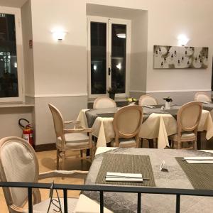 a dining room with tables and chairs and windows at Hotel Spagna in Arona