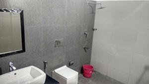 a bathroom with a sink and a toilet and a shower at Hotel Neptune Kovalam in Trivandrum +18 photos