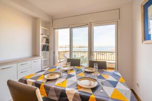 een eetkamer met een tafel en uitzicht op de oceaan bij Apartment Meritxell in L'Escala